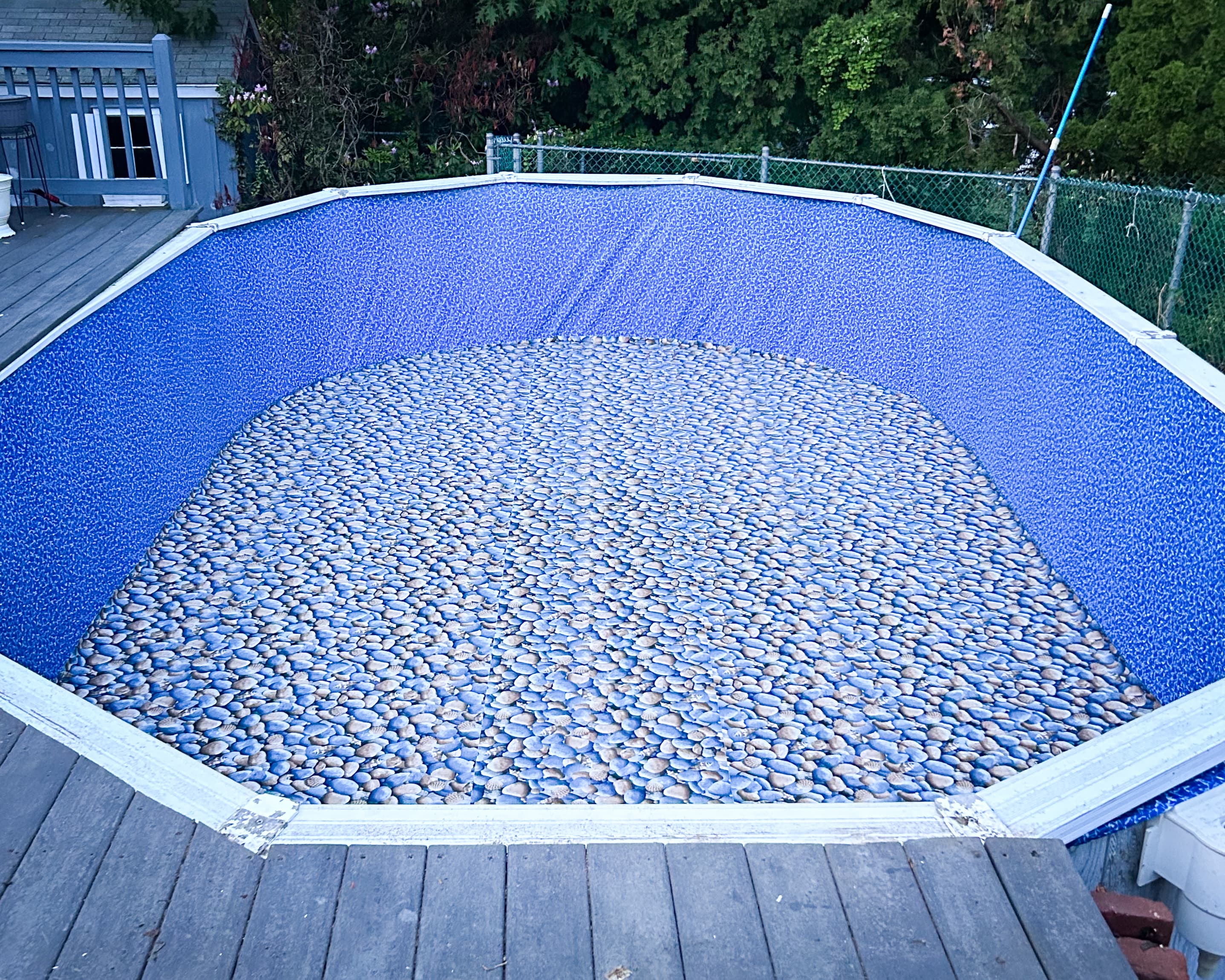 Close-up of a pool with newly installed blue liner with stone pattern detail around the edges